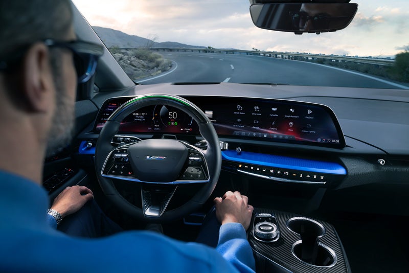 Front View of the 2026 OPTIQ-V Driving Through the Dusk Utilizing its Headlights | Ed Morse Sawgrass Cadillac in Sunrise FL