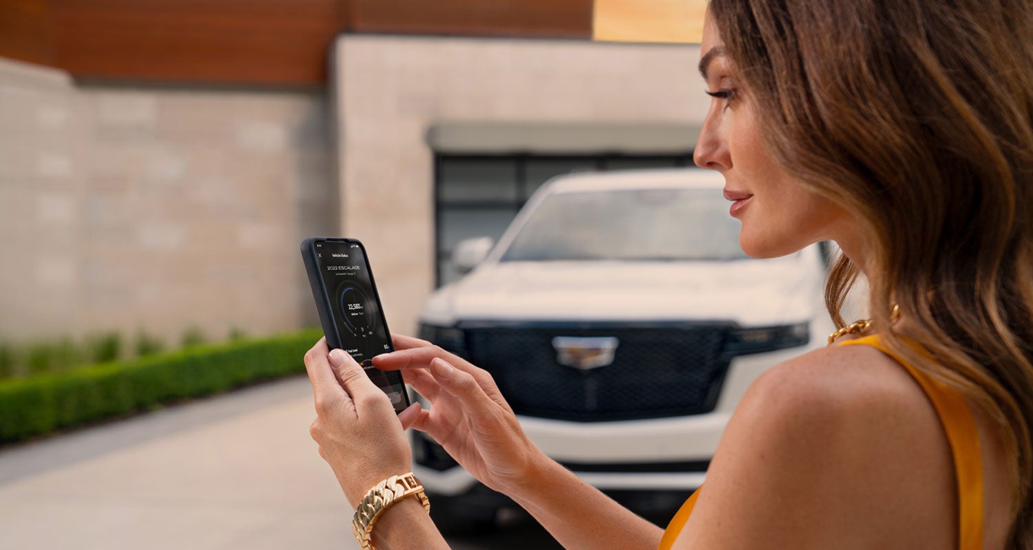 lady checking her mobile with a Cadillac vehicle background | Ed Morse Sawgrass Cadillac in Sunrise FL
